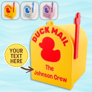 Könnte beinhalten: Gelber Briefkasten mit roten Akzenten und den Worten "DUCK MAIL" und "The Johnson Crew". Eine rote Entengrafik befindet sich in der Mitte. Enthält einen kreisförmigen Bereich für benutzerdefinierten Text. Drei kleinere Briefkästen befinden sich im Hintergrund.