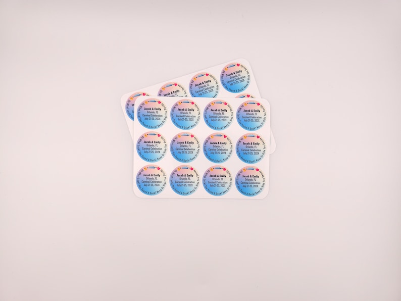 May include: Two sheets of round stickers with a gradient blue and pink background. Each sticker has text that reads "Jacob & Emily, Orlando, FL, Carnival Celebration, July 25, 2020, A Soul & Body Keep in Tune!"
