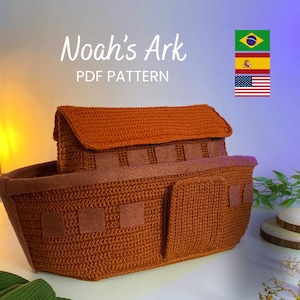 Pode incluir: Uma Arca de Noé de crochê marrom, com um telhado retangular e janelas quadradas. O texto "Noah's Ark PDF PATTERN" é exibido em branco. Bandeiras do Brasil, Espanha e Estados Unidos no fundo.