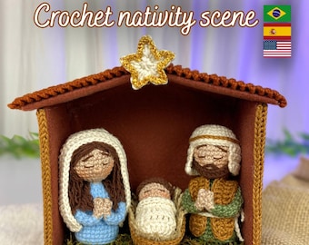 May include: A crochet nativity scene with figures of Mary, Joseph, and baby Jesus in a brown stable. The yarn figures are in blue, white, and brown. A gold star sits atop the stable, and the text "Crochet nativity scene" is displayed.