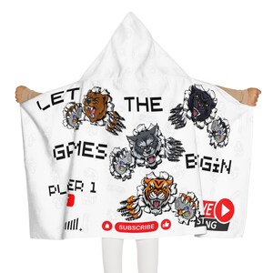 May include: White hooded blanket with a gaming theme. It features the text "Let the games begin" with a variety of animal characters breaking through the fabric. The blanket also includes a YouTube logo and the text "Subscribe".