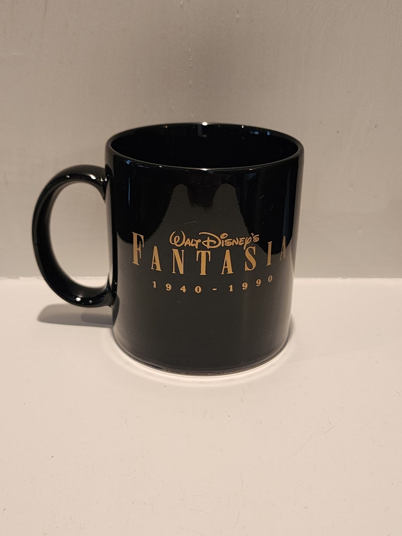 May include: Black ceramic mug with a gold inscription that reads "Walt Disney's Fantasia 1940 - 1990".