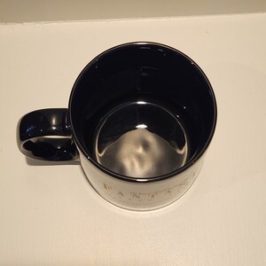 May include: Black ceramic coffee mug with a gold rim and the words "Everything is better with coffee" printed on the side.
