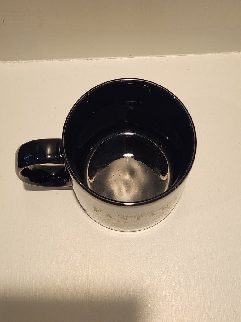 May include: Black ceramic coffee mug with a gold rim and the words "Everything is better with coffee" printed on the side.
