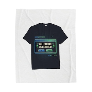 May include: Black t-shirt with a computer error message design. The message, in a blue and green frame, reads "AN ERROR OCCURRED" with "OK" and "CANCEL" buttons. The shirt is displayed on a white background.