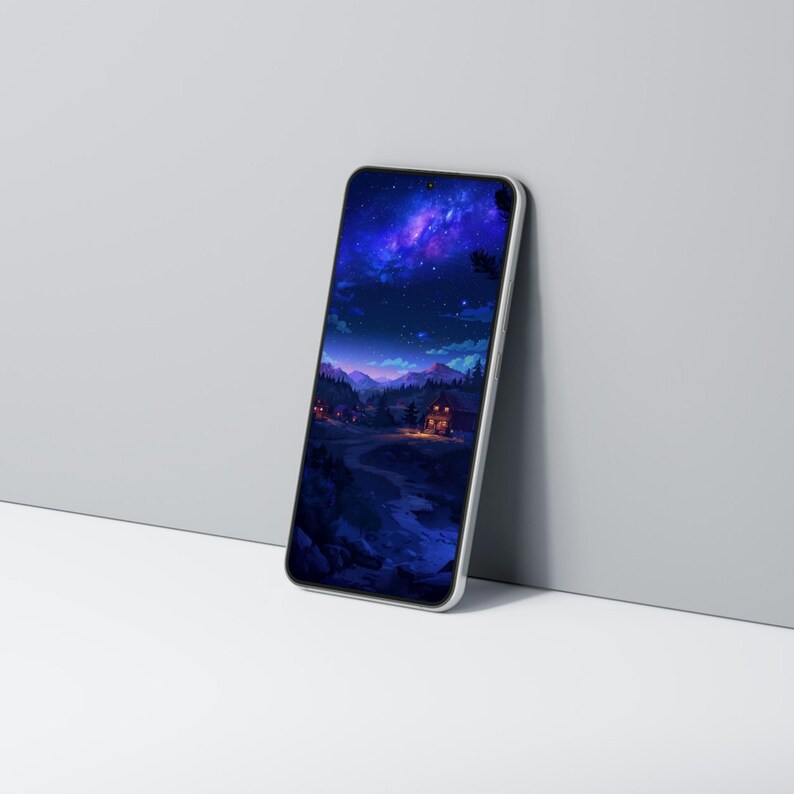 Op de afbeelding: Een zilveren smartphone toont een digitale kunstsc&egrave;ne van een sterrenhemel boven een berglandschap met verlichte huizen. Het scherm toont een diepblauwe en paarse kleurenpalet.