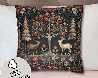 May include: A decorative throw pillow with a dark blue background featuring a stylized tree with red flowers, two deer, and a forest scene. The pillow has a red, gold, and white border.