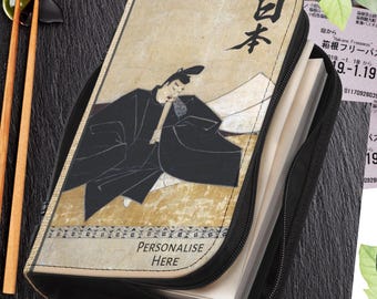 May include: Black zippered case with a Japanese art print. The print features a figure in traditional clothing, with the Japanese word for "Japan" at the top. The text "PERSONALISE HERE" is at the bottom.