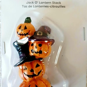 May include: A Jack O' Lantern stack mini decoration in retail packaging labeled Ashland Halloween. The item features three orange carved pumpkins stacked vertically, with the top two wearing dark purple witch hats, all on a dark base.