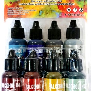 May include: A set of eight 0.5-ounce bottles of alcohol inks in various colors, including Rosewood, Sienna, Dijon, Moss, Turquoise, Vineyard,  and  Mud. The bottles are labeled "Ranger Alcohol Inks".