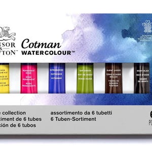 May include: A watercolor paint set by Winsor & Newton Cotman. The box contains six tubes of paint in various colors, including yellow, pink, blue, green, brown, and black. The packaging features the brand's logo and the words "Watercolour".
