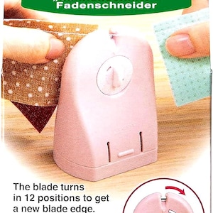 May include: Pink thread cutter with the text "Quick Cut" and Clover logo. The blade turns in 12 positions to get a new blade edge. The package also includes text in French, Spanish, and German.