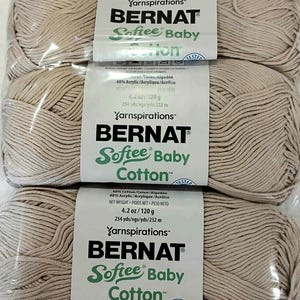 May include: Two skeins of Bernat Softee Baby Cotton yarn in a light beige color. The yarn is 60% cotton and 40% acrylic. Each skein weighs 4.2 ounces and contains 254 yards of yarn.
