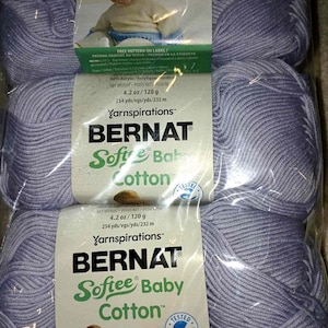 May include: Three skeins of Bernat Softee Baby Cotton yarn in a light purple color. Each skein is 4.2 oz (120 g) and contains 254 yards (232 m) of yarn. The packaging includes a picture of a baby and the text "Soft Baby Cotton".