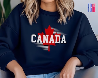 Puede incluir: Una sudadera azul marino con una hoja de arce roja y la palabra "CANADA" en letras blancas.