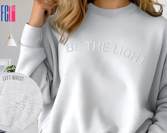 Felpa ricamata "Be The Light": abbigliamento con versetti della Bibbia cristiana