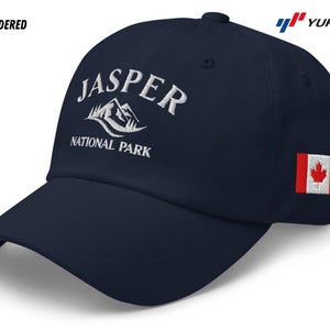 Może przedstawiać: Czapka bejsbolowa w kolorze granatowym z białym haftem z napisem "Jasper National Park" i białym wzorem góry. Czapka ma również małą naszywkę z flagą Kanady z boku.
