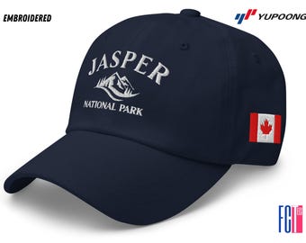 May include: A navy blue baseball cap with white embroidered text that reads "Jasper National Park" and a white mountain graphic. The cap also has a small Canadian flag patch on the side.