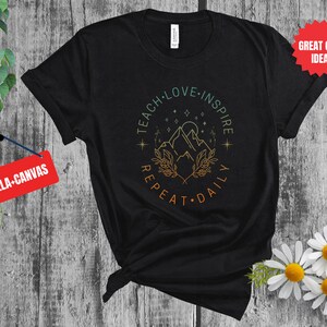 May include: Black t-shirt with a graphic design of a mountain range with stars and the text "Teach Love Inspire Repeat Daily".
