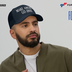 Puede incluir: Una gorra de camionero azul marino con una malla blanca en la parte posterior. La gorra tiene un texto bordado en blanco que dice "MAKE AMERICA GO AWAY".