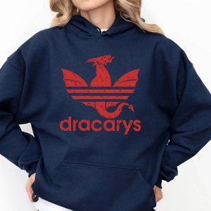 May include: A navy blue hoodie with a red dragon logo and the word "dracarys" printed on the front.
