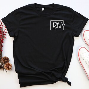 May include: Black t-shirt with a white square on the front that says "RN" with a small heart next to it.