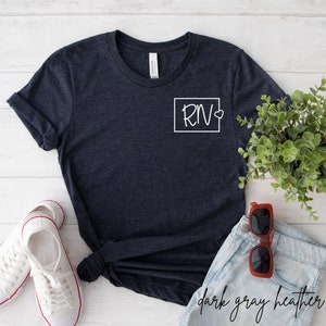May include: Dark grey heather t-shirt with a white square on the left chest that says "RN" with a heart.