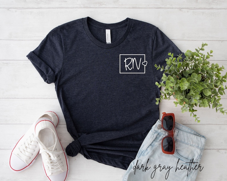 May include: Dark grey heather t-shirt with a white square on the left chest that says "RN" with a heart.
