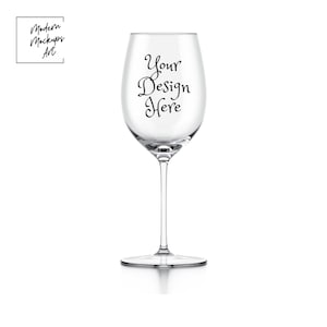 Peut inclure: Un verre à vin en verre transparent avec un pied et un large bol. Le verre porte l'inscription "Your Design Here" imprimée sur le côté.