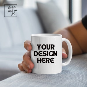 May include: White ceramic mug with a black handle. The mug has the text "YOUR DESIGN HERE" printed on the front.