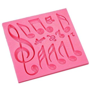 May include: Pink silicone mould with multiple musical note shapes, including treble clefs and quavers.