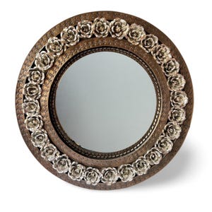 Puede incluir: Un espejo redondo con un marco decorativo hecho de rosas de metal. El marco es de color bronce con detalles plateados. El espejo es perfecto para agregar un toque de elegancia a cualquier habitación.
