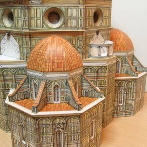May include: A detailed paper model of the Duomo in Florence, Italy. The model is made of paper and cardboard and features intricate details, including the dome, the facade, and the bell tower.