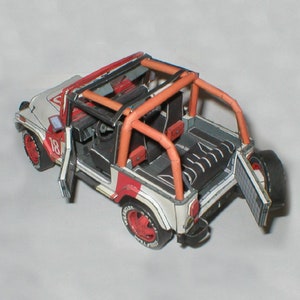 Może przedstawiać: Papierowy model Jeepa w kolorze białym, czerwonym i czarnym z klatką bezpieczeństwa, otwartymi drzwiami i otwartymi tylnymi drzwiami. Jeep ma numer "18" na boku.