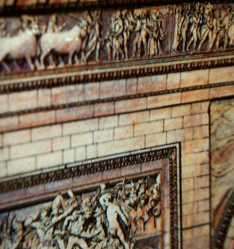 May include: Close-up of a section of a detailed relief sculpture, featuring figures and animals. The relief is carved into a light-colored material, with a brick-like pattern below. The artwork has a classical style, with intricate details and a sense of depth.