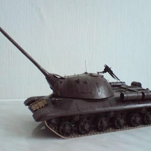 May include: A detailed model of a dark brown tank with a long barrel. The tank features intricate details, including wheels, tracks, and a machine gun on top. The model is set against a plain background.