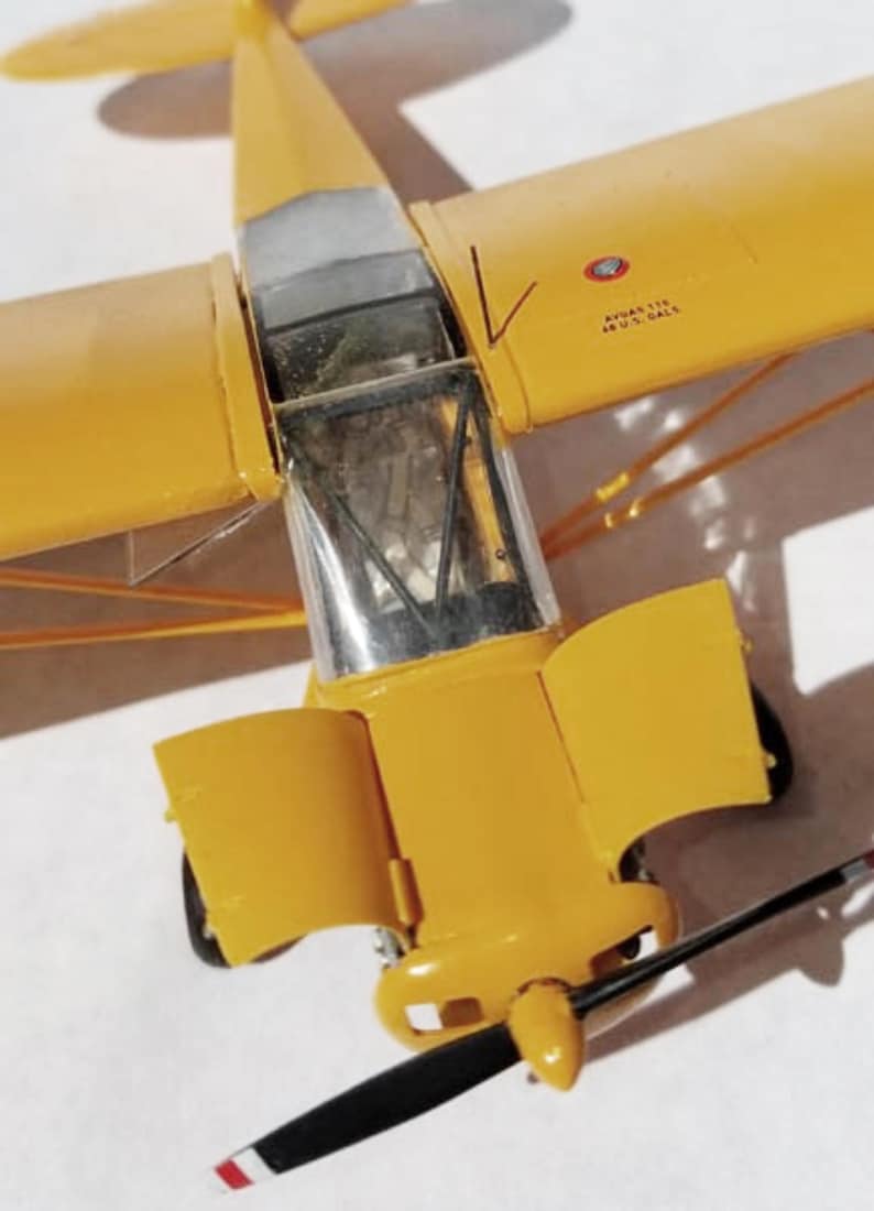 Puede incluir: Maqueta detallada de avi&oacute;n en amarillo brillante, con cabina transparente y h&eacute;lice en blanco y negro. Las alas y el fuselaje son de color amarillo liso, con detalles visibles como la cola y el tren de aterrizaje. El modelo es una r&eacute;plica en miniatura.