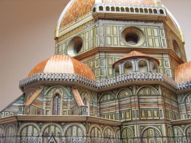 May include: A detailed model of the Duomo in Florence, Italy. The model is made of paper and features intricate details, including the dome, the facade, and the surrounding buildings.
