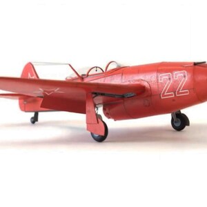 May include: A red model aircraft with the number 22 on the side. The plane has a white star on the tail.