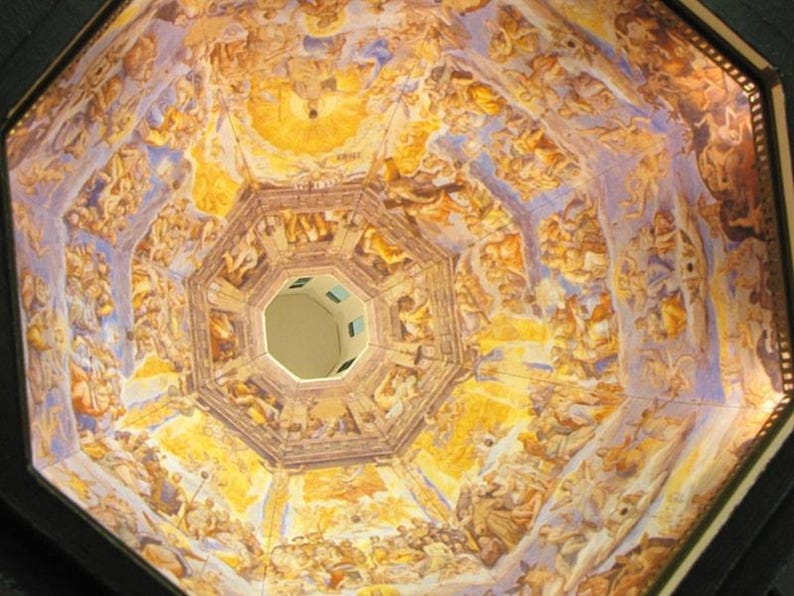 May include: A close-up view of a painted ceiling with a circular opening in the centre. The ceiling is painted in shades of yellow, blue, and white, with intricate details and figures. The circular opening reveals a glimpse of the sky.