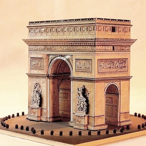 Puede incluir: Maqueta detallada del Arco del Triunfo, con intrincados detalles arquitectónicos. El modelo es principalmente beige y marrón, con figuras esculpidas y arcos. Se asienta sobre una base rectangular con pequeños postes oscuros.