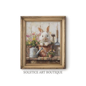 May include: A framed painting of a white rabbit sitting in a flower pot with a watering can and gardening tools. The background is a light wood panel.
