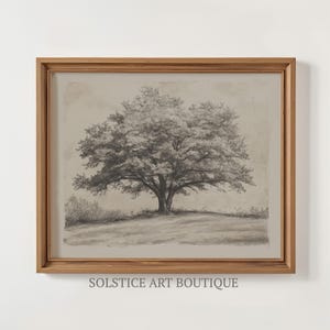 May include: A framed black and white pencil drawing of a large tree in a field. The drawing is on a textured paper with a light brown background. The frame is a simple wooden frame.