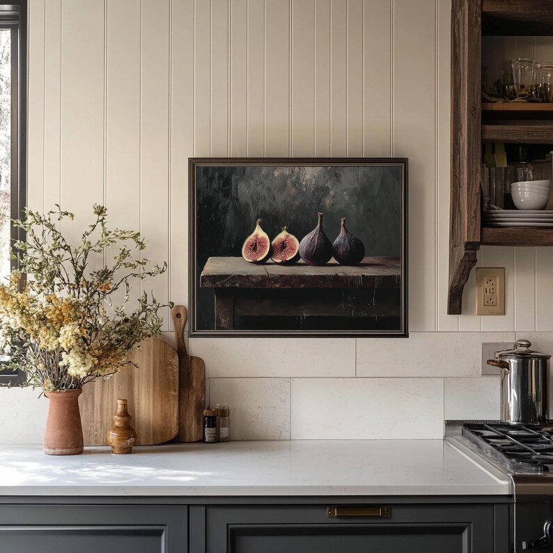 Pode incluir: Uma pintura emoldurada de tr&ecirc;s figos em uma mesa de madeira. Os figos s&atilde;o roxos e cortados ao meio. O fundo &eacute; verde escuro e cinza.
