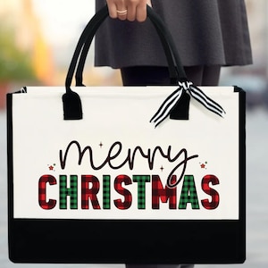 May include: White canvas tote bag with black handles and a black bottom. The bag has a red and green plaid design with the words "merry christmas" in black script.
