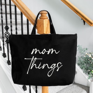 May include: Black canvas tote bag with white text that reads "mom things".
