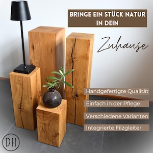 Könnte beinhalten: Vier quadratische Holzsockel in verschiedenen Höhen, aus naturbelassenem Holz mit Knoten und Maserungen. Die Sockel sind versetzt angeordnet, mit einer kleinen Pflanze in einem schwarzen Topf auf dem kleinsten Sockel. Der Text "BRINGE EIN STÜCK NATUR IN DEIN Zuhause" ist im Hintergrund sichtbar.