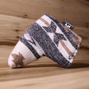 Op de afbeelding: Golfclubhoofdhoes met een geometrisch patroon in cr&egrave;me, zwart en bruin. De hoes heeft een rechthoekige vorm met een afgeronde punt en een klein zwart label met witte tekst. De hoes is gemaakt van een geweven stof.
