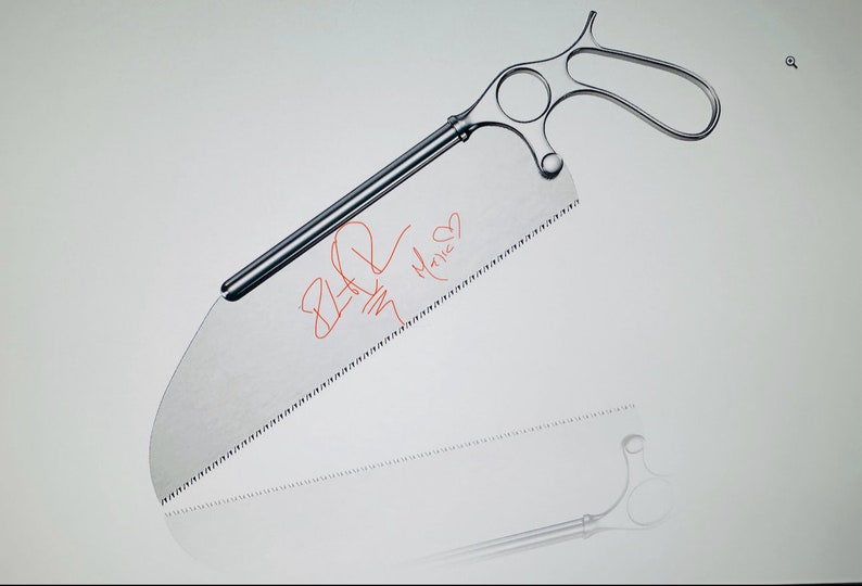 May include: A silver surgical saw with a handle and a serrated blade. The blade has red writing on it that says "8-20" and "Marie".