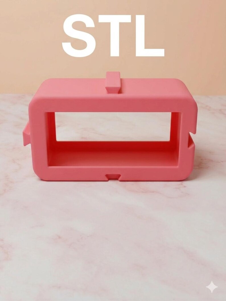 May include: A vibrant pink rectangular object with the letters "STL" in white above. The object features a rectangular aperture in the centre and a small tab on top. It rests on a pink surface.